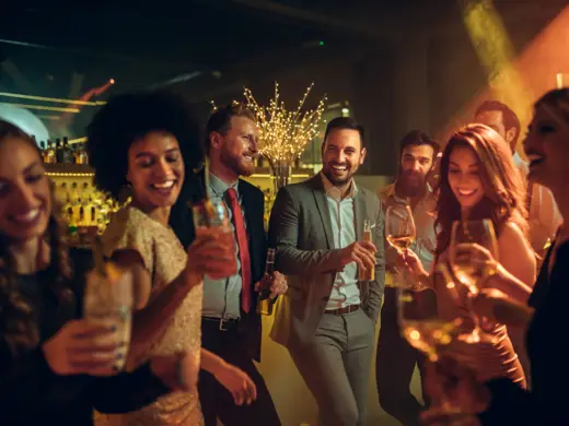 Silvesterparty Viele Menschen tanzen mit Getränken in einer Bar.