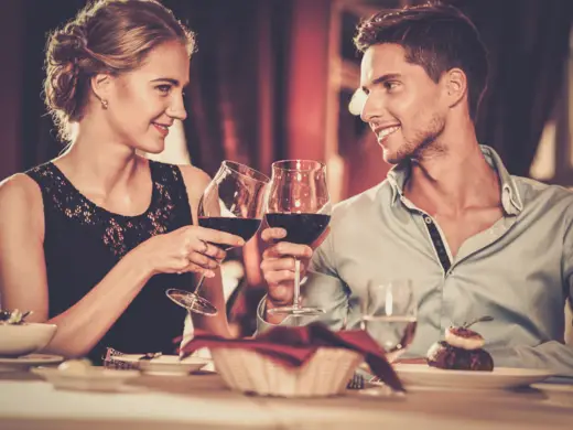 Ein Paar prostet sich mit Rotwein zu.